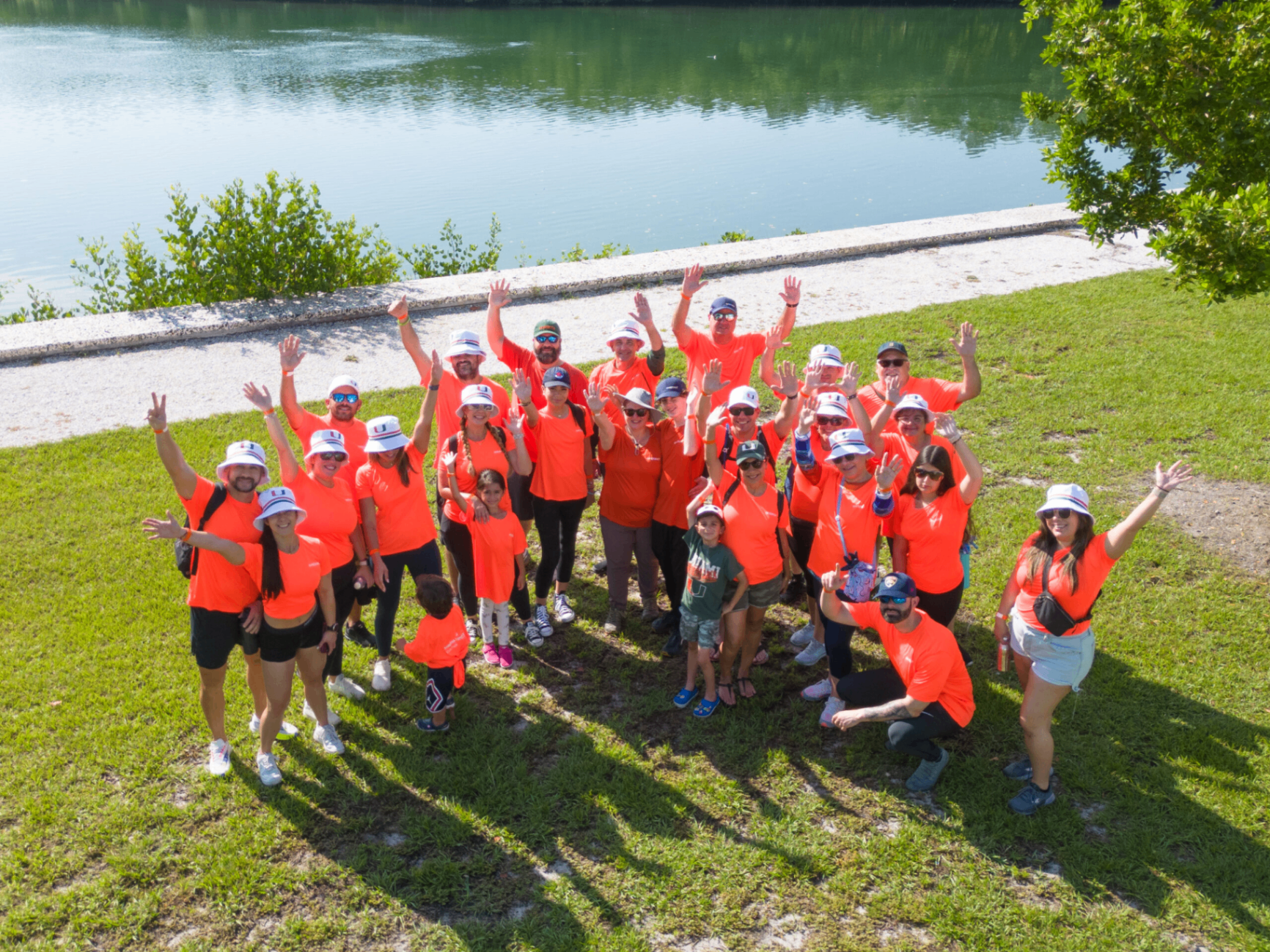 Amerant Bank employees in orange team shirts celebrating outdoors